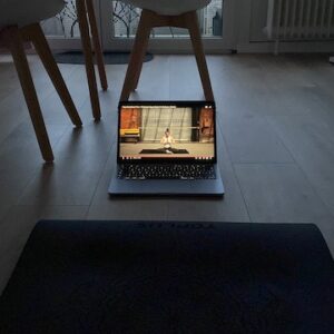 Therapieerfahrungen hochmaskierter Autismus: Zu sehen ist ein Foto einer Yogamatte und eines Laptops mit einem Yogavdeo in der Wohnung der Autorin