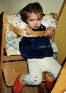 Autismus Diagnose im Erwachsenenalter: Kinderfoto von Marlene, auf dem sie verzweifelt versucht, aus ihrem Kinderstuhl auszubrechen.