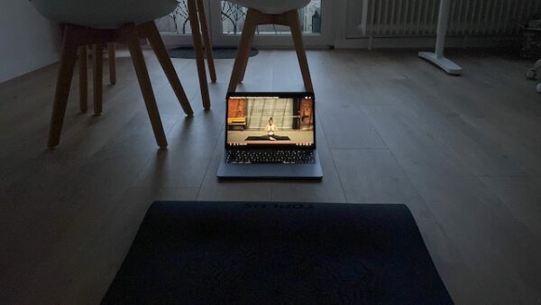 Therapieerfahrungen Autismus: Foto aus Marlene´s erster Wohnung. Zu sehen ist eine Yogamatte mit einem Laptop davor, auf dem ein Yogavideo abgespielt wird.