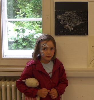 Masking und Identität: Kinderfoto von Marlene mit knapp 7 Jahren und ihrem Kuscheltier im Arm. Sie schaut unsicher zur Seite und versucht sich über Stimming-Verhalten mit ihren Händen zu regulieren.