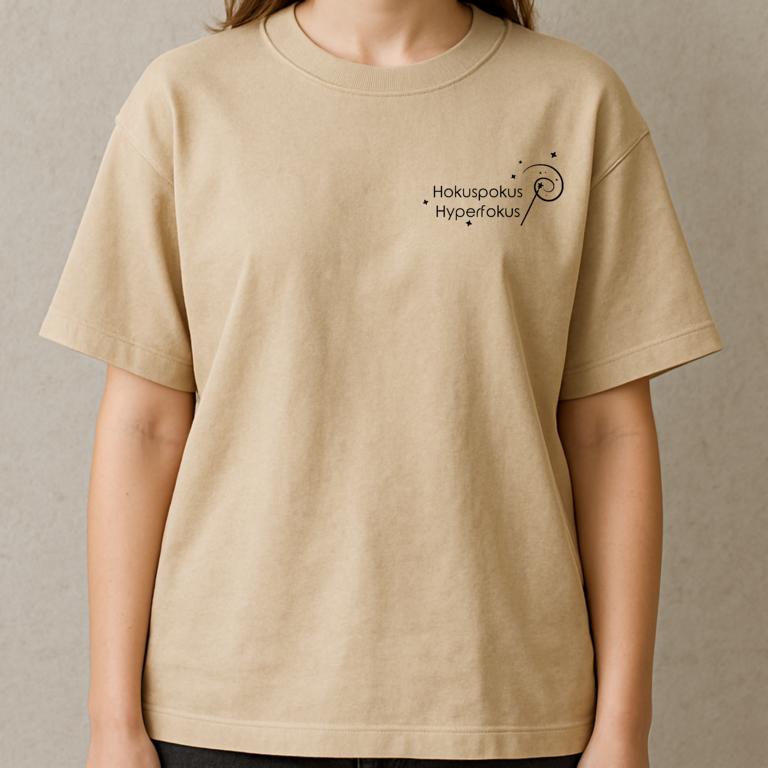 Gefaltetes T-Shirt mit minimalistischer Zauberstab-Grafik und dem Schriftzug „Hokuspokus Hyperfokus“ – humorvolles Design für ADHS & Neurodivergenz.