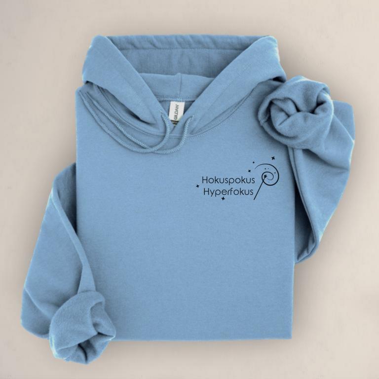 Gefalteter Hoodie mit minimalistischem Aufdruck „Hokuspokus Hyperfokus“ und Zauberstab-Illustration – humorvolles Statement für ADHS, AuDHD und Hyperfokus.